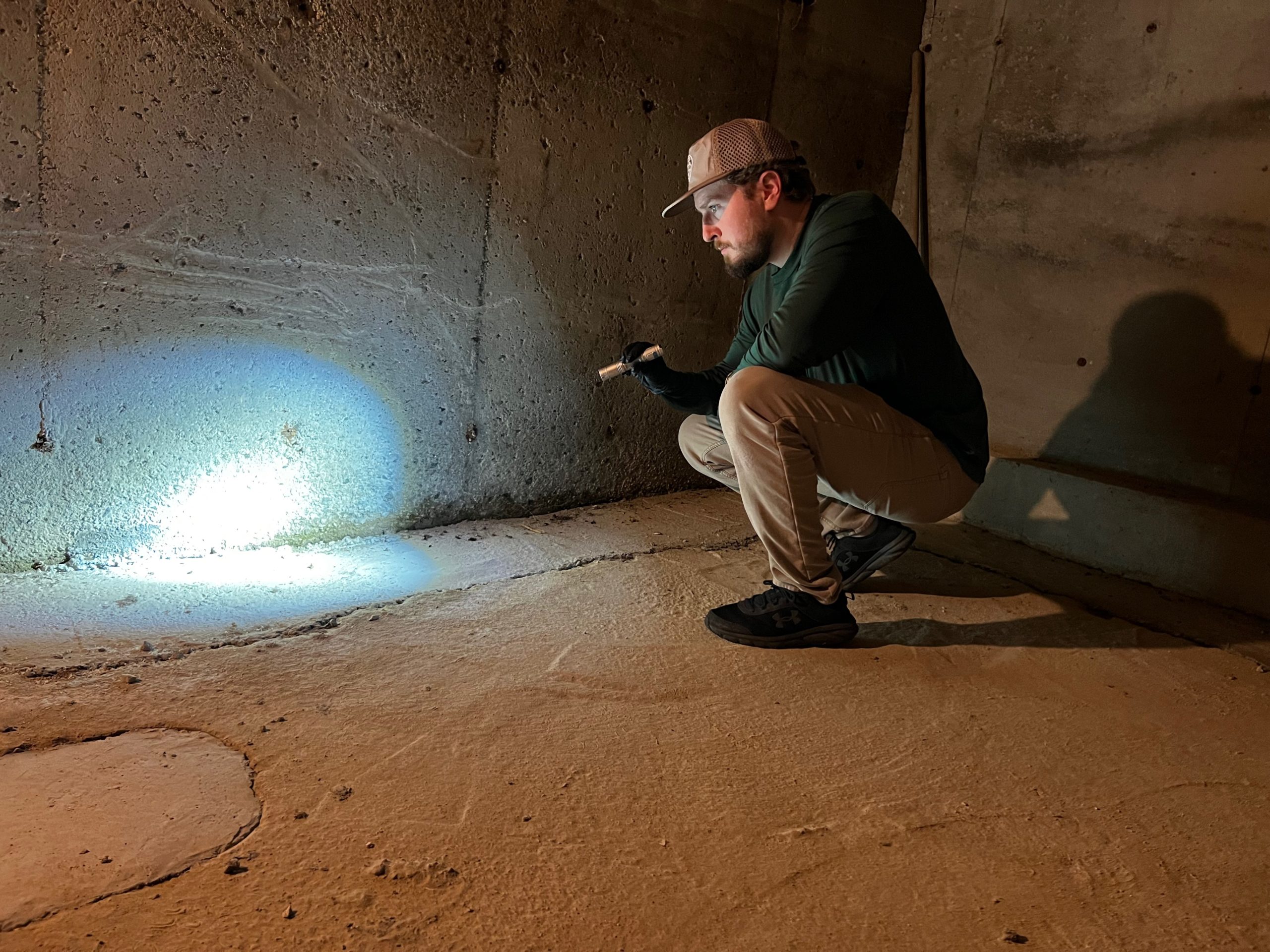 Pest Control Technician Inspecting Basement