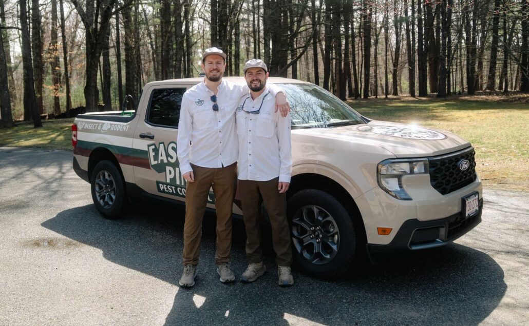 Photo of Ty and Tanner in front of the Eastern Pine Pest Control Truck
