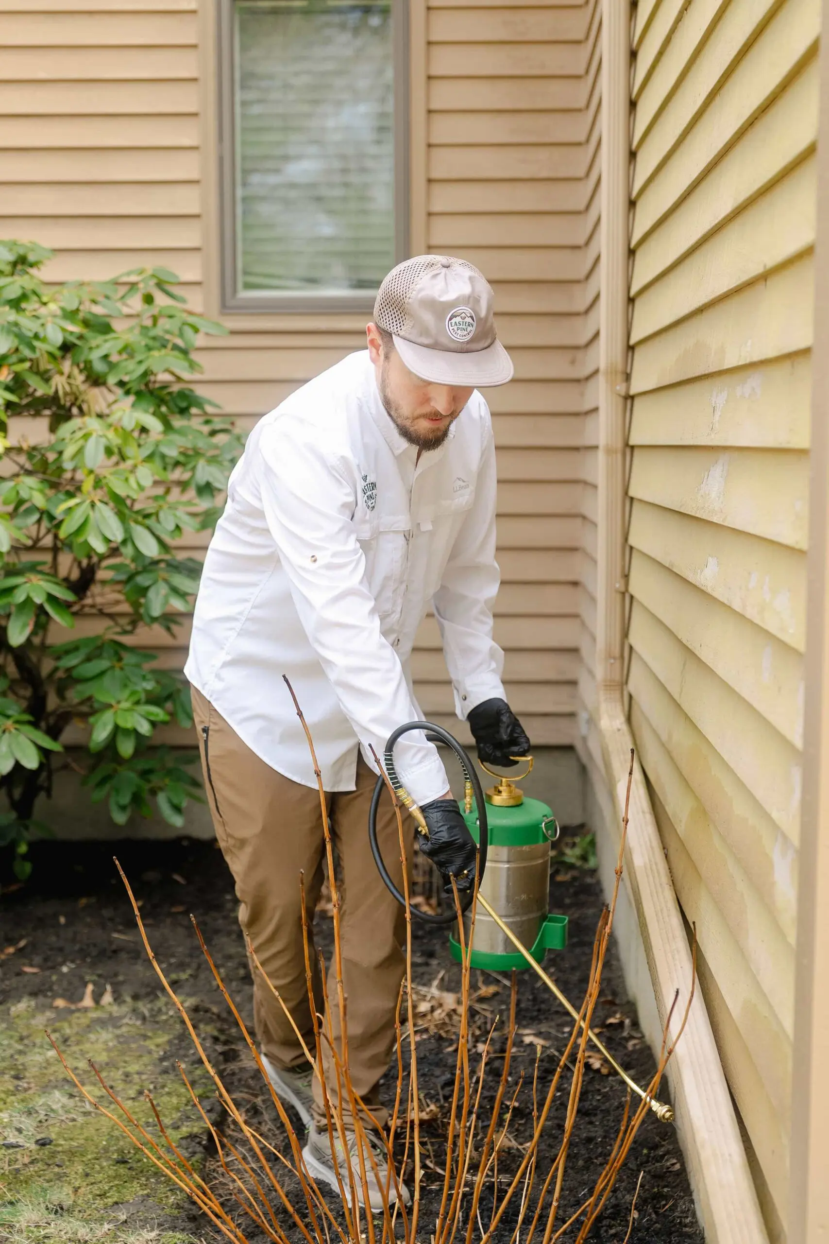 Eastern Pine Pest Control technician performing a targeted Integrated Pest Management treatment around a home